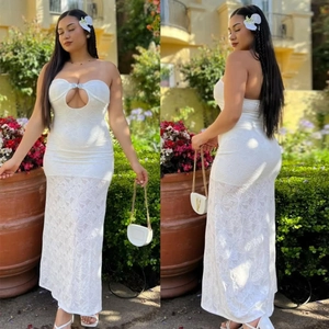 Outdoor shot of a white floral lace strapless dress with cutout front detail