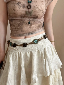 Detailed shot of bohemian waist chain with wooden beads and turquoise bronze pendants