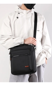 Close-up of black vertical crossbody bag with adjustable wide strap and AoTian logo detail