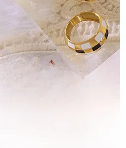 Nahaufnahme des goldenen breiten Rings mit Emaille-Schachbrettmuster im Vintage-Stil
