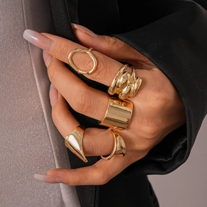 Close-up of gold geometric rings set worn on hand with modern aesthetic styling