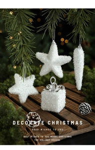 White Christmas ornaments with stars and gift boxes on green pine branches with bokeh