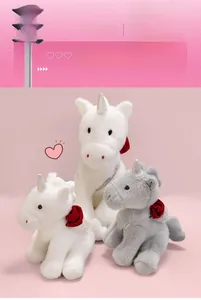 Three plush unicorn dolls in white and grey colors with rose flower detail and neck ribbons