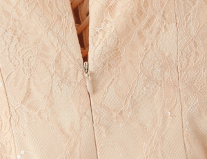 Detail von unsichtbarem Reißverschluss und Spitzenstickerei an der Taille eines Kleides