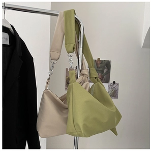 Detail of minimalist hobo bags in beige and avocado green with silver metal chains