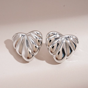 Macro shot of silver heart studs featuring shell-like texture and striped metallic finish