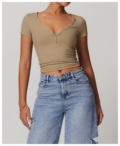 Close-up of the V-neck detail and button-up design on the slim-fit khaki yoga crop top