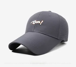 Detail view of dark gray baseball cap with white 'on!' embroidery and laser-cut vents