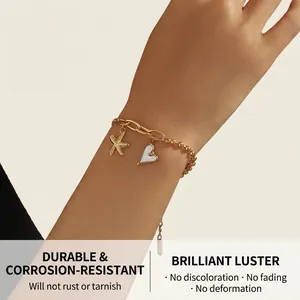 Gros plan détaillé du bracelet en acier doré 18 carats avec breloques étoile et cœur