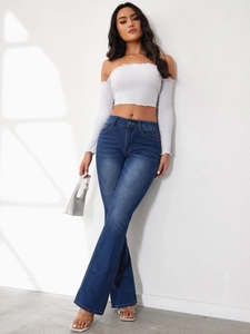 Detail of high waist stretch flare jeans in dark blue with chic slim fit denim texture