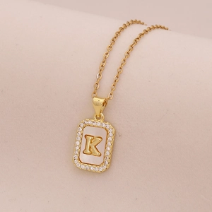 Détail du pendentif lettre K en or 18K avec nacre et contour en cristaux brillants