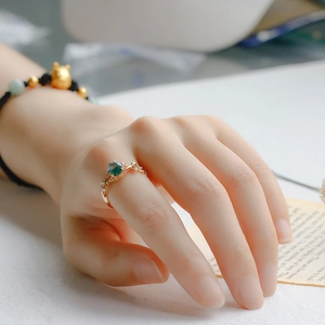 Close-up of a leaf-shaped moss agate ring with cubic zirconia on a model's finger