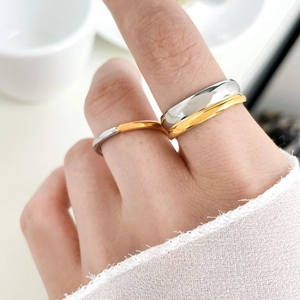 Close-up of dual-tone oval titanium steel ring featuring gold and silver polished finish
