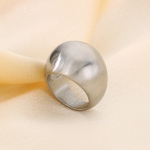 Close-up of polished silver stainless steel dome ring on soft textured fabric