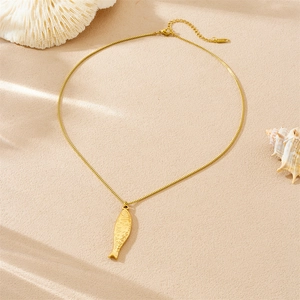 Gold-plated stainless steel fish pendant necklace on elegant beige textured background