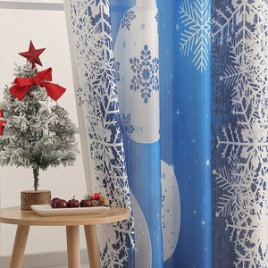 Detail of Christmas curtain featuring large white snowflakes and blue festive ornaments