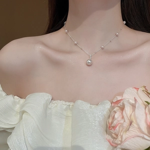 Close-up of elegant irregular pearl pendant necklace on model with vintage style