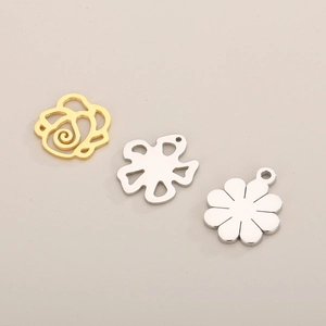 Detail of hollow and solid rose flower pendants in gold and silver finish for DIY