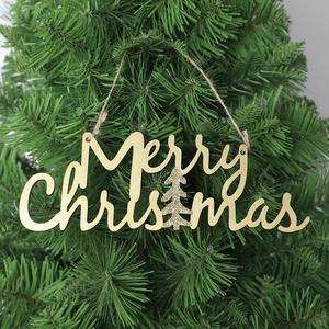 Glittering gold Merry Christmas wooden hanging sign on a green pine tree branch