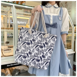 Detail of tropical parrot and leaf print on canvas tote bag with cotton rope handles