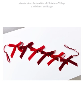 Detail of six red velvet bows arranged on a white background for festive Christmas decor
