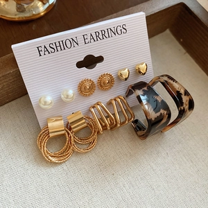 Detailed set of butterfly pearl heart earrings displayed on textured cardstock