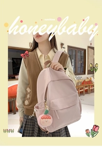 Close-up of pink casual backpack with side water bottle pocket and cute doll charm