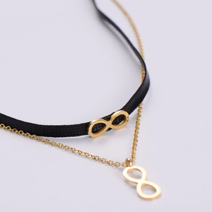 Choker double couche minimaliste avec bande en tissu noir, chaîne dorée et breloque infini