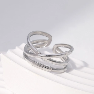 Minimalist silver multi-layer crisscross open ring on elegant white stone display