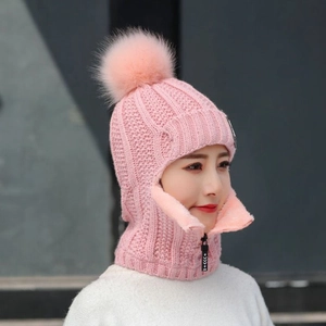 Détail de la cagoule tricotée rose avec pompon en fausse fourrure et col à fermeture éclair