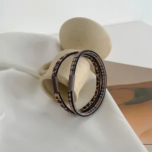 Pair of leopard print seamless elastic hair ties with high stretch on ceramic holder