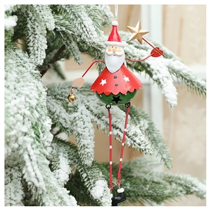 Detail of hanging Santa Claus metal ornament on snowy Christmas tree branch with a gold star