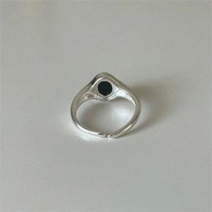 Macro view of minimalist 925 silver ring featuring round black agate and open band