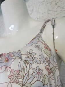 Close-up of chiffon floral dress showing delicate ruffled straps and neckline details