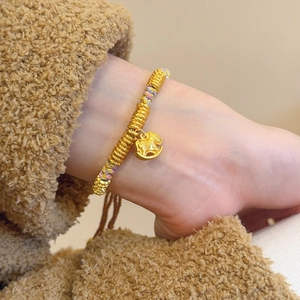 Macro detail of hand-woven colorful cord bracelet with golden rocking horse pendant
