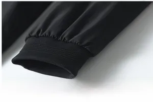 Close-up of elastic ribbed cuffs on a black windproof bomber jacket with sleek finish