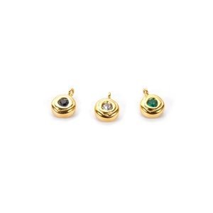 Three 18K gold plated evil eye charms with black, clear, and green crystals on white base