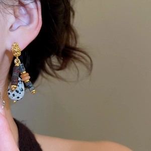 Detailed close-up of a vintage ethnic earring with dalmatian stone and colorful beads