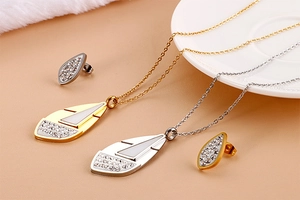 Detail of leaf-shaped gold and silver jewelry set with rhinestones on ceramic plate