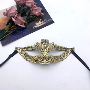 Close-up of golden lace masquerade mask with black silk ribbons and decorative roses