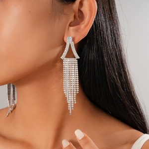 Gros plan de boucles d'oreilles pendantes argentées avec strass sur le modèle