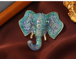 Close-up of elephant brooch with sparkling blue and green crystals on gold metal base