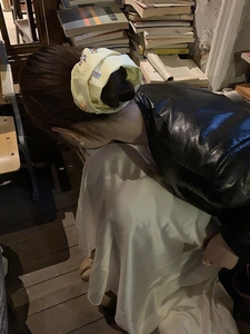 Dettaglio di un elastico giallo chiaro con ricami floreali sui capelli della modella