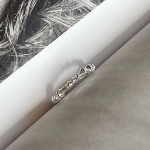 Artistic 925 sterling silver ring with twisted thread texture placed in book pages