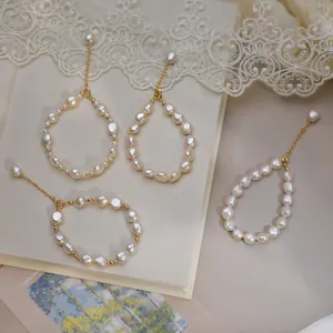 Detail of baroque pearl bracelets with 14K gold-filled chains on vintage artistic background