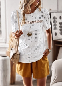 Close-up of white short sleeve top featuring intricate hollow embroidery and lace details