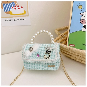 Detail of mint green tweed girls purse with pearl handle and bow for autumn fashion