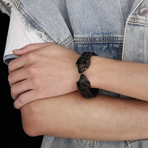 Detail of a black skull leather bracelet on a wrist showcasing punk and gothic style