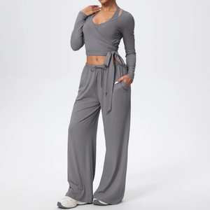 Détail d'un ensemble de yoga gris avec haut à manches longues croisé et pantalon large