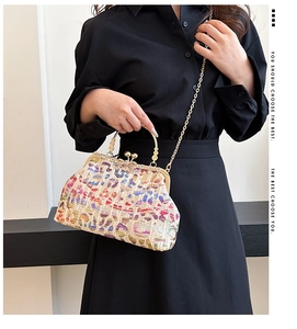 Macro shot of colorful woven texture and gold metal ball clasp on evening clutch bag